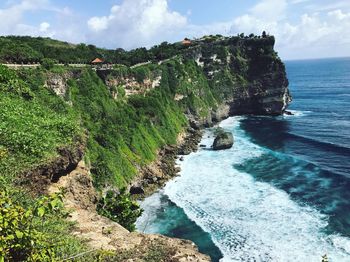 Scenic view of grassy cliff by sea