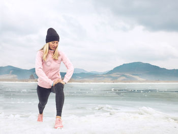 Portrait of young woman standing at beach