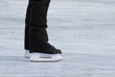 Low section of man ice-skating on rink