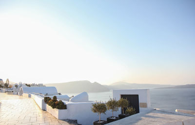 Scenic view of town by sea against clear sky