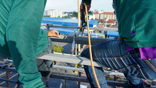 Welding of metal structures on extension of a building. sparks and smoke fly as steel is welded.