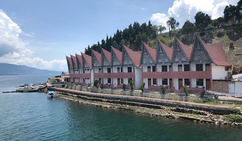 Panoramic view of buildings by river against sky