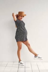 Full length of woman standing against white background