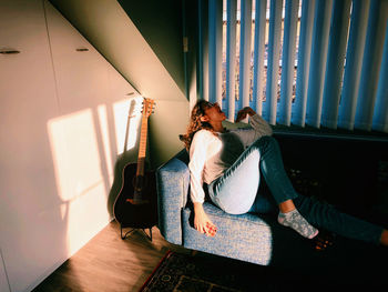 Woman with mouth open sitting on sofa at home