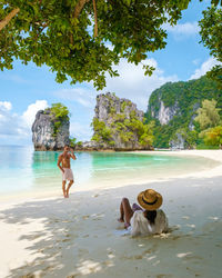 Rear view of woman sitting on beach