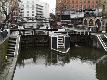 Bridge over canal by buildings in city