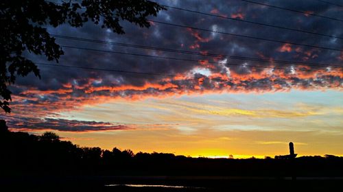 Silhouette of landscape against cloudy sky