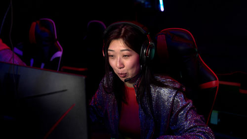 Young woman using computer in darkroom