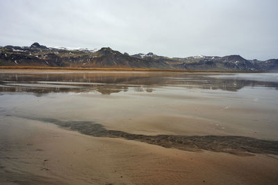 Mountains near tranquil sea water