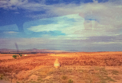 Hay bales on field against sky