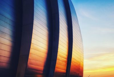 Low angle view of glass building against sky