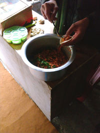 Close-up of hand holding bowl of table