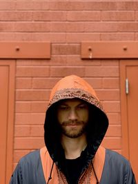 Man looking down while standing against wall