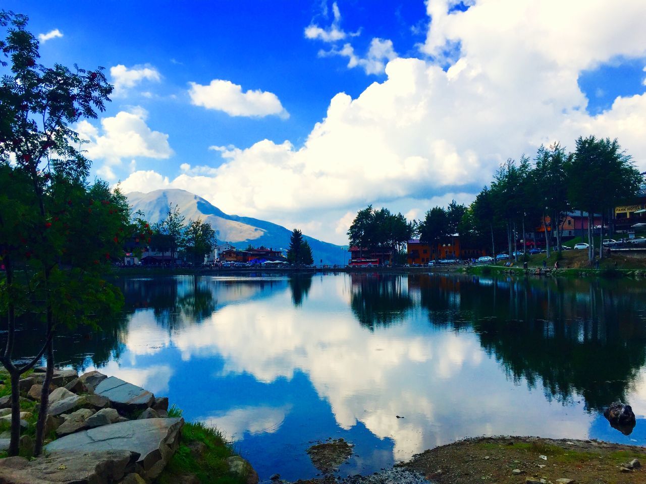 reflection, water, lake, sky, tree, tranquil scene, tranquility, cloud - sky, mountain, scenics, beauty in nature, cloud, standing water, nature, blue, mountain range, river, idyllic, symmetry, calm