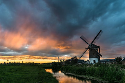 Dutch windmill with colorful rain streaks lit by the setting sun