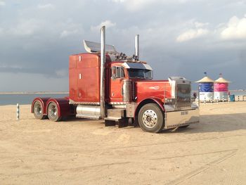 View of semi-truck on sand by lake