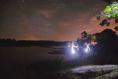 Scenic view of illuminated trees against sky at night