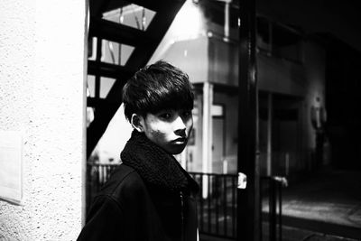 Portrait of young man looking through window