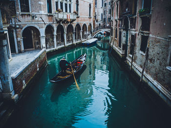 High angle view of boats on canal amidst buildings in city