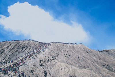 Hikers on mountain against sky