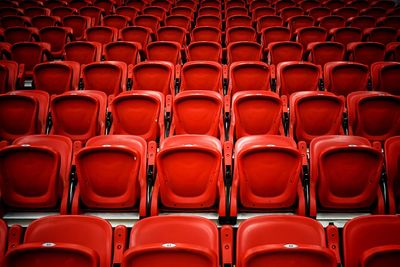 Full frame shot of empty red bleachers in stadium