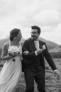 Front view of couple standing against sky