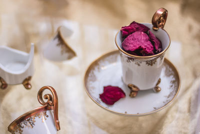 Close-up of red flower in cup on table