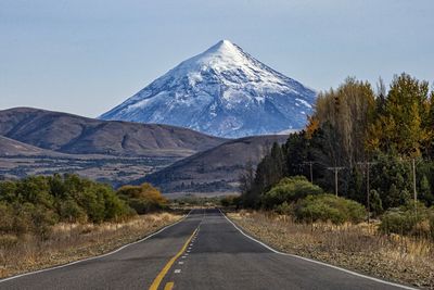 Road by mountains against sky