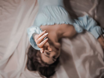 High angle view of woman lying on bed