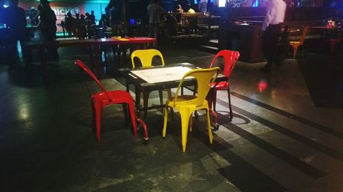 Empty chairs and table in restaurant at night