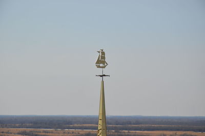 Low angle view of cross on field against clear sky