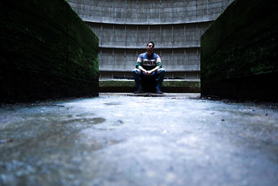 Full length of man sitting in tunnel