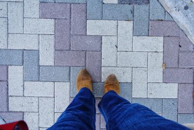 Low section of man standing on tiled floor