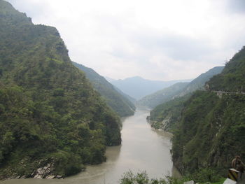 Scenic view of river amidst mountains against sky