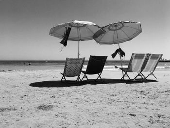 Umbrella on beach against clear sky