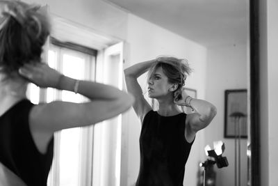 Young woman looking away while standing at home