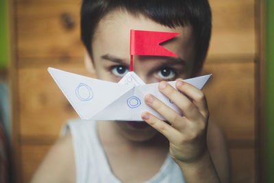 Portrait of boy holding paper boat