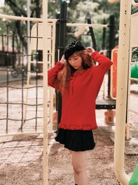 Portrait of woman with red umbrella standing outdoors