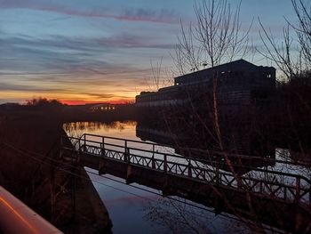 Bridge over river against sky during sunset