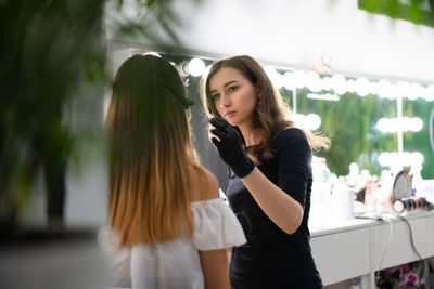 Close-up of woman getting make-up