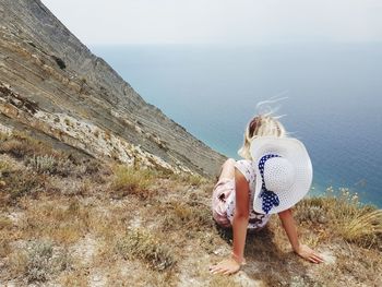 Woman looking at sea shore against sky