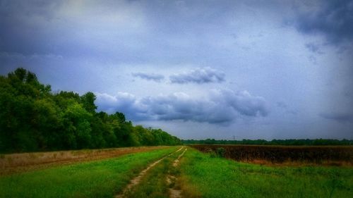 Scenic view of field against cloudy sky