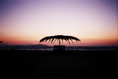 Silhouette palm tree on beach against sky during sunset