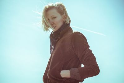 Portrait of a young woman against clear sky