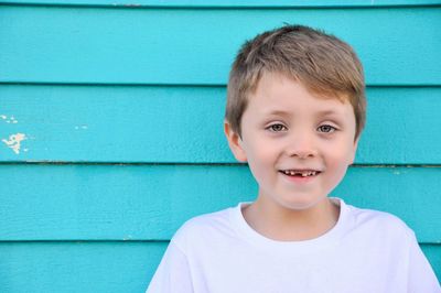 Portrait of smiling boy against wall