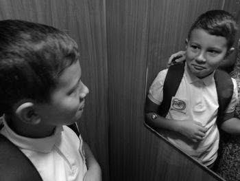 High angle view of cute boy looking in mirror