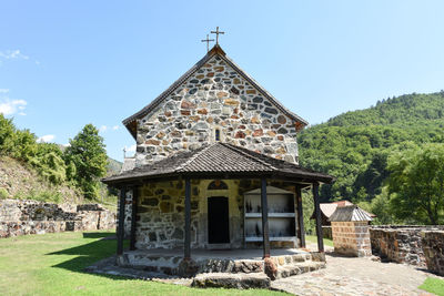 Traditional building by trees against sky