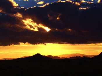 Scenic view of silhouette mountains against sky during sunset