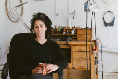 Candid environmental portrait of california jewler sitting in studio