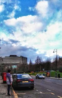 Cars on road in city against sky